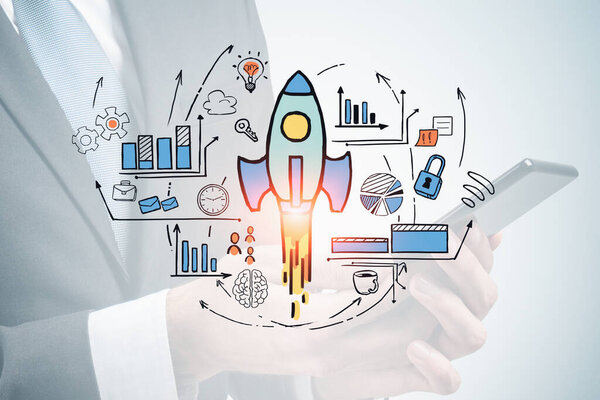 Hands of businessman using smartphone over blurry white background with double exposure of colorful startup sketch. Concept of new project launch. Toned image