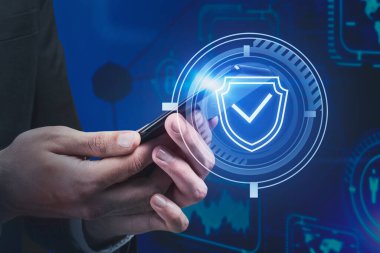 Bulanık mavi arka plan üzerinde akıllı telefon kullanan iş adamlarının elleri gelecekteki siber güvenlik arayüzünü iki kez gösteriyor. Veri koruması kavramı. Tonu ayarlanmış resim