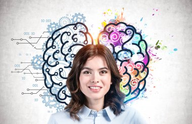 Üzerinde renkli sol ve sağ beyin çizimi olan beton duvarın yanında duran koyu saçlı neşeli Avrupalı genç bir kadın. Yaratıcı ve analitik düşünme kavramı