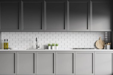 Modern mutfağın içinde beyaz tuğla duvarlar, koyu mavi dolaplar ve lavabo ve fırında yapılmış tezgahlar var. 3d oluşturma