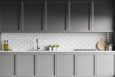 Interior of modern kitchen with white brick walls, dark blue cupboards and countertops with built in sink and cooker. 3d rendering clipart