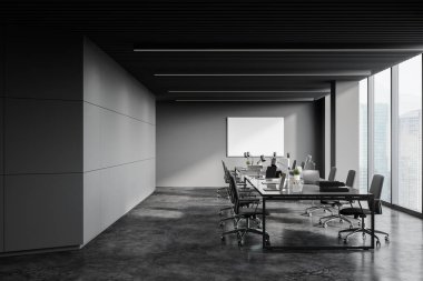 Koyu gri duvarları, beton zemini, uzun bilgisayar tabloları, bulanık şehir manzaralı yatay maketi ve penceresi olan panoramik açık uzay ofisinin içi. 3d oluşturma