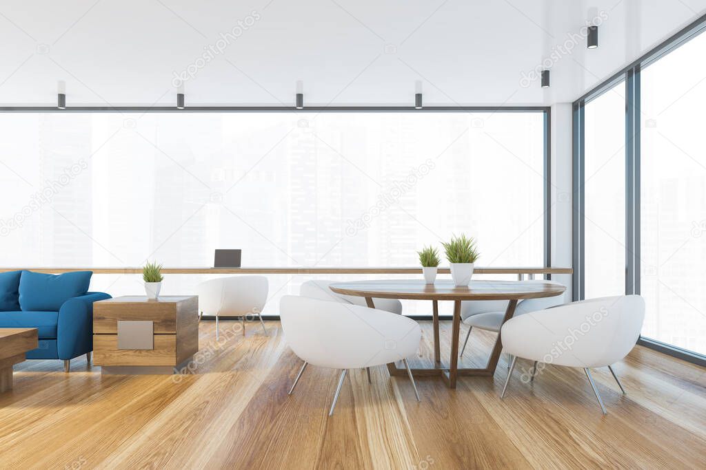 Interior of spacious living room with blue sofa, coffee table, round dining table with white armchairs and home office area near window with blurry cityscape. 3d rendering
