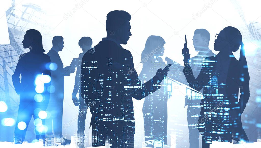Teamwork concept. Silhouettes of diverse business people working together in abstract city with double exposure of blurry night cityscape. Toned image