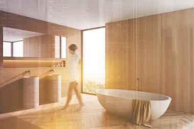 Lüks banyoda, tahta ve bej duvarları, rahat küveti, aynalı çift lavabosu ve tropikal manzaralı pencereleri olan bulanık genç bir kadın. Renkli resim çift pozlama