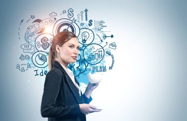 Gri duvarın yanında kahve içen Avrupalı genç ve güzel bir iş kadını. Üzerinde yaratıcı iş stratejisi taslağı çizilmiş. Planlama ve başarı kavramı. Model