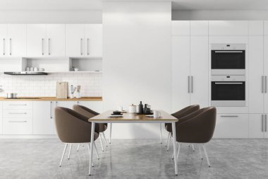Beyaz ve tuğladan duvarları, beton zemini, beyaz dolapları ve tezgahları olan fırınlarda ve kahverengi koltuklu yemek masasında inşa edilmiş modern mutfağın içi. 3d oluşturma