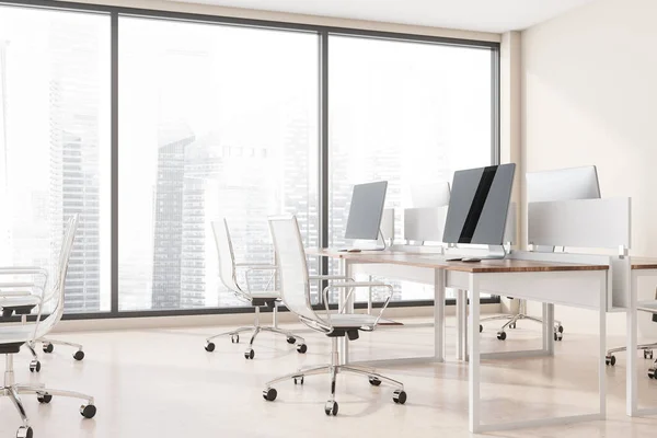 Corner of modern open space office with beige walls, concrete floor, rows of white and wooden computer tables and panoramic window with blurry cityscape. 3d rendering