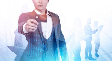Tanımlanamayan genç iş adamı, bulanık bir şehirde, takımını ve gezegen hologramını iki kez gösteren bir kredi kartı gösteriyor. Bankacılık ve finansal hizmetler kavramı. Tonu ayarlanmış resim