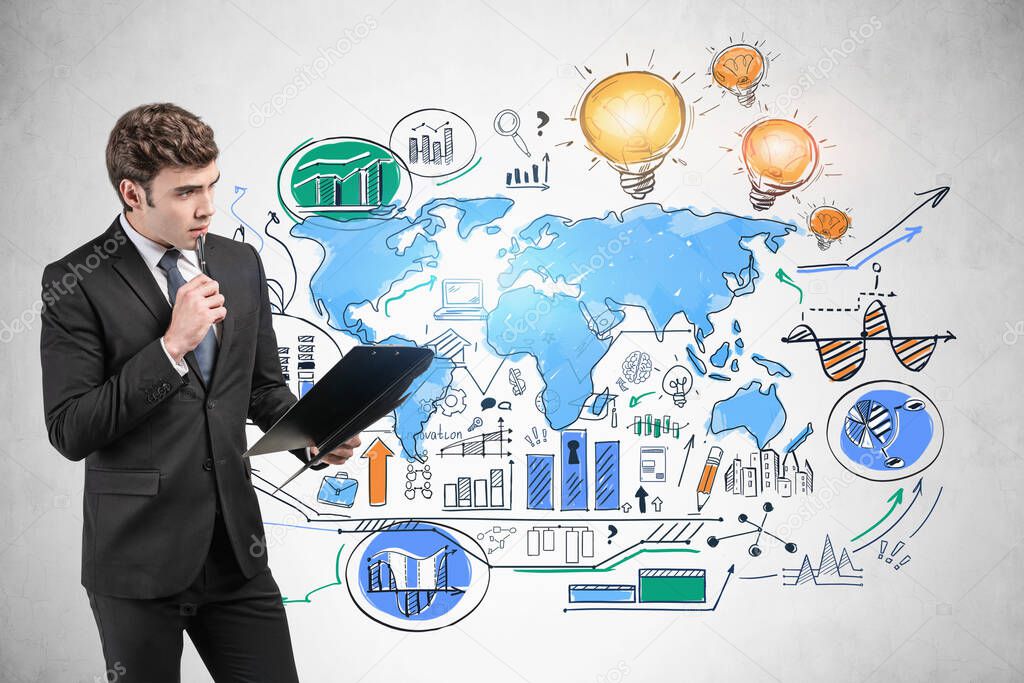 Thoughtful young European businessman with clipboard standing near concrete wall with colorful global business sketch. Business strategy concept. Elements of this image furnished by NASA
