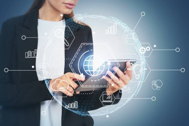 Gri arkaplan üzerinde tablet bilgisayar kullanan tanımlanamayan genç bir kadın, çift katmanlı bulut bilgisayar arayüzü kullanıyor. Tonu ayarlanmış resim
