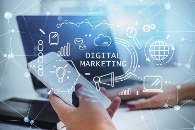 Bulanık ofiste akıllı telefon ve dizüstü bilgisayar kullanan iş kadınının elleri. Parlak dijital pazarlama arayüzü iki kez kullanılıyor. E- ticaret anlayışı. Tonu ayarlanmış resim