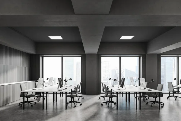 Side view of industrial style open space office with gray and wooden walls, concrete floor and rows of white computer tables. Blurry cityscape. 3d rendering