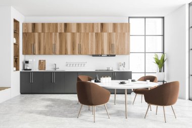 Beyaz tuğlalı duvarları, beton zemini, ahşap dolapları ve gri dolapları olan modern mutfağın içi. Kahverengi koltuklu yuvarlak yemek masası. Bulanık şehir manzarası. 3d oluşturma