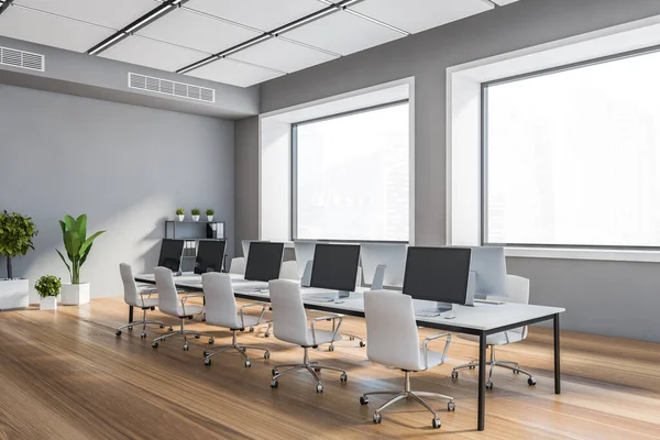 Gri duvarları, ahşap zemini, sandalyeli uzun beyaz bilgisayar masası ve bulanık manzaralı pencereleri olan şık, açık uzay ofisinin köşesi. 3d oluşturma