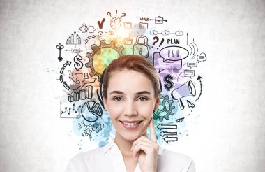 Üzerinde yaratıcı iş planı çizimi olan beton duvarın yanında duran neşeli genç iş kadını.