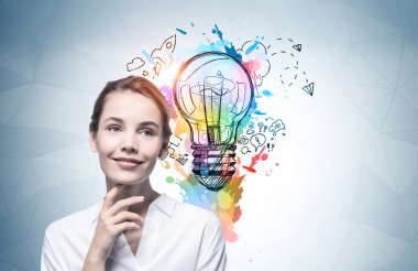 Üzerinde renkli iş fikri çizimi olan gri duvarın yanında duran gülümseyen genç Avrupalı iş kadını..