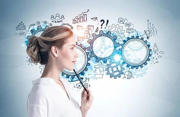 Üzerinde iş stratejisi çizimi olan gri duvarın yanında duran düşünceli genç iş kadını. Planlama kavramı