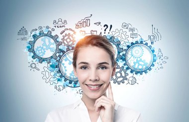 Üzerinde yaratıcı iş stratejisi çizimi olan gri duvarın yanında duran neşeli genç iş kadını.