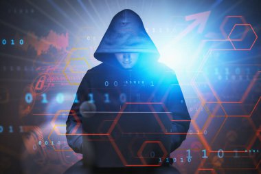 Siyah kapüşonlu genç hacker bilgisayarını arka planda bulanık kullanıyor ve iki kez dijital arayüze maruz kalıyor. Tonu ayarlanmış resim