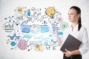 Üzerinde renkli bir çizim olan beton duvarın yanında duran ciddi genç bir iş kadını.