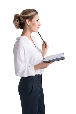 Düşünceli genç Avrupalı iş kadınının defter ve kalemle izole edilmiş bir yan portresi.