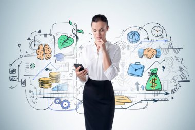 Düşünceli genç iş kadını mavi duvarın yanındaki akıllı telefon ekranına renkli bir iş çizimiyle bakıyor.