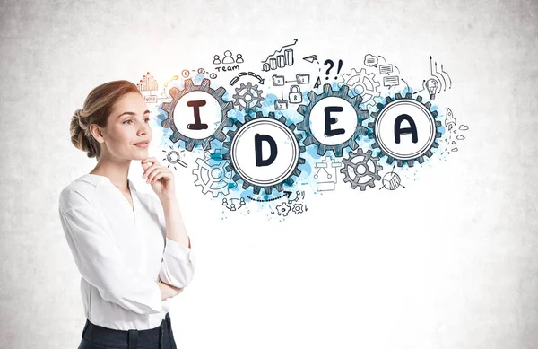 Üzerinde yaratıcı bir çizim olan beton duvarın yanında duran düşünceli genç iş kadını.