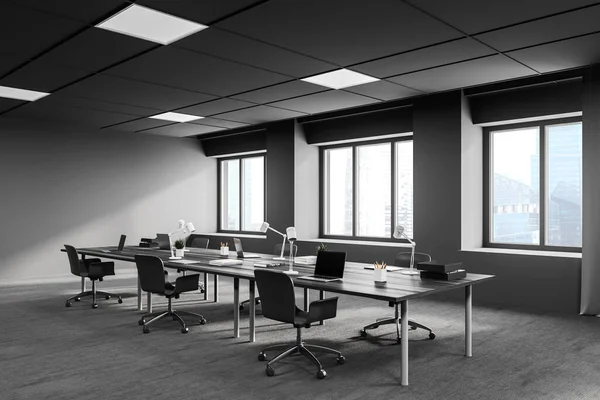 Gri duvarları, halı döşemeleri ve büyük bilgisayar tabloları olan modern açık uzay ofisinin köşesi. 3d oluşturma