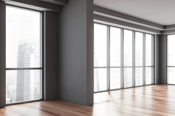 Corner of empty apartment with gray walls, wooden floor and panoramic windows with blurry cityscape. 3d rendering