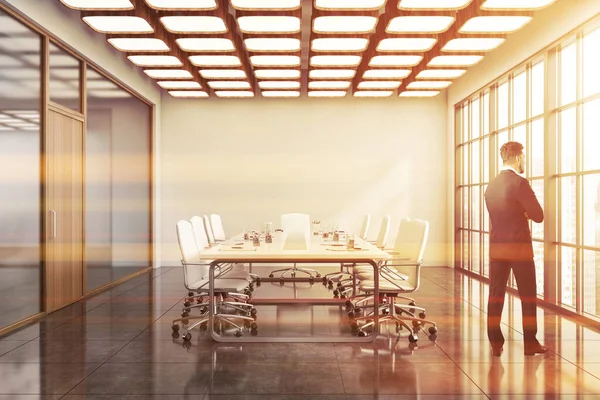 白い壁 タイル張りの床 長い会議テーブルを備えたモダンな会議室に立つ若いヨーロッパのビジネスマン トーン画像 — ストック写真