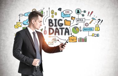 Akıllı telefonlu genç işadamının renkli büyük veri çizimiyle beton duvarın yanında dikilirken yan görüntüsü