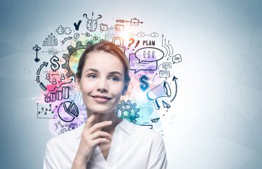 Üzerinde renkli bir iş çizimi olan gri duvarın yanında düşünen neşeli genç bir iş kadını. Model