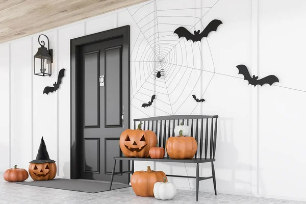 Carved pumpkins, bats and spiders near black front door of modern house with white walls and black bench. Side view. Concept of halloween. 3d rendering