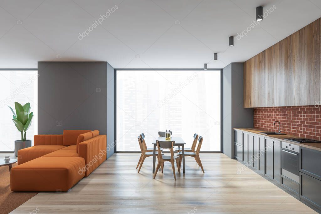 Side view of modern living room with gray walls, wooden floor, orange sofa and kitchen in background. 3d rendering