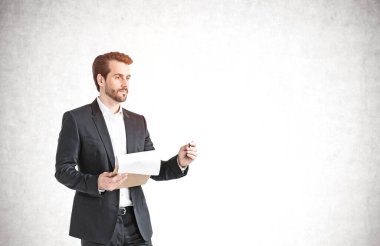 Beton duvarın yanında tablet bilgisayar kullanan sakallı genç Avrupalı iş adamının portresi. Teknoloji kavramı. Model