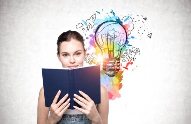 Üzerinde parlak bir çizim olan beton duvarın yanında duran genç iş kadını..