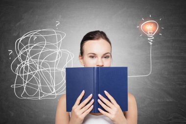 Üzerinde çizim olan tahtanın yanında duran genç iş kadını..