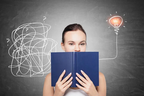 Üzerinde çizim olan tahtanın yanında duran genç iş kadını..