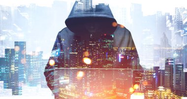 Bulanık şehirde laptopunu kullanan kapüşonlu genç hacker. Siber güvenlik kavramı. Renkli resim iki kat genişletme