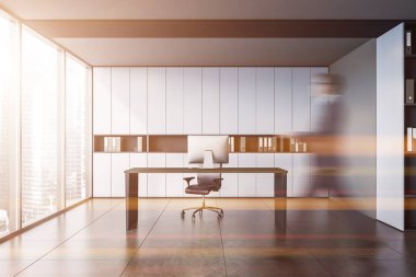 Bulanık genç işadamı, beyaz ve gri duvarları, döşemeleri ve bilgisayar masası olan modern CEO ofisinde yürüyor. Yönetim kavramı. Tonu ayarlanmış resim