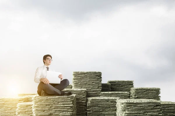 Young European Businessman Laptop Sitting Stacks Dollars Blue Sky Background — Stock Photo, Image