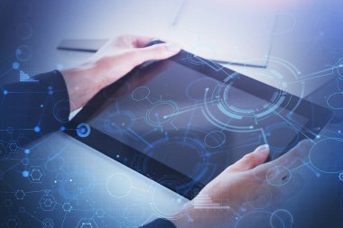 Bulanık ofiste tablet kullanan iş kadınının elleri iki kat HUD ağ arayüzü kullanıyor. Tonu ayarlanmış resim