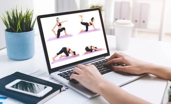 女人的手放在笔记本电脑上 在模糊的桌子上打字 看瑜伽式的录像 美与健康的概念 被投掷的图像 — 图库照片