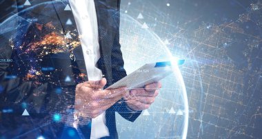 Bilinmeyen iş adamı, gezegenin arka planında tablet kullanıyor. Görüntüye iki kez maruz kalmışsın. Bu görüntünün elementleri NASA tarafından desteklenmektedir