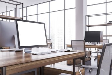 Modern açık ofis köşesinde beyaz duvarları ve beton zemini olan ahşap bir masanın üzerinde duran ekranı taklit eden bilgisayar. 3d oluşturma
