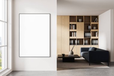 Çağdaş ofis içi, beyaz duvarda büyük dikey poster modeli, minimalist ahşap kitaplık ve kanepe, gün ışığı arka planı. 3B Hazırlama
