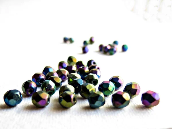 Iris rainbow coated glass beads on white background. Hobby, jewelry making, DIY, fine art. Craft concept. Close-up. — Stock Photo, Image