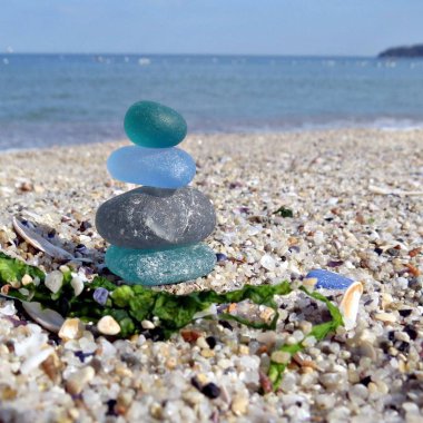 Deniz manzarası arka plan ile plaj kumüzerinde renkli deniz cam. Beachcombing