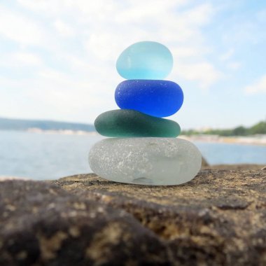 Deniz manzarası arka plan ile plaj kaya renkli deniz cam piramit. Seaglass yığını plaj tarama